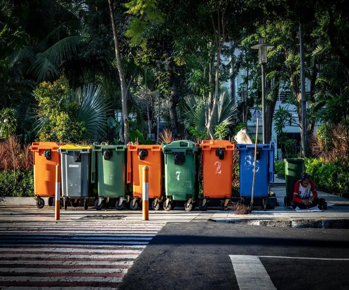 Different coloured skip bins on a roadside showing mackay skip bin hire and skip bin hire mackay price list options